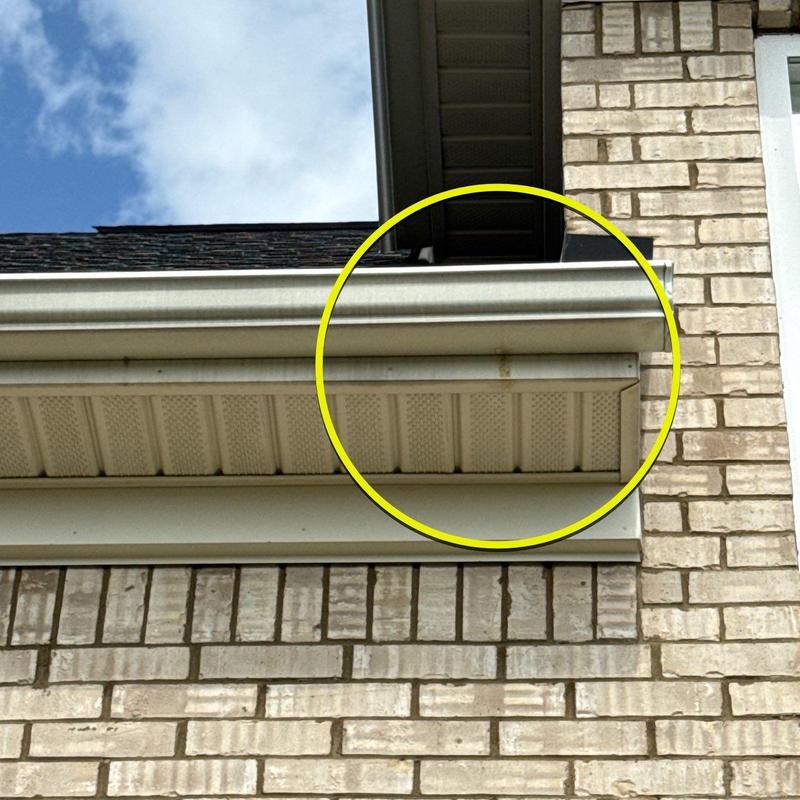 Gutter section with rust stains on house exterior