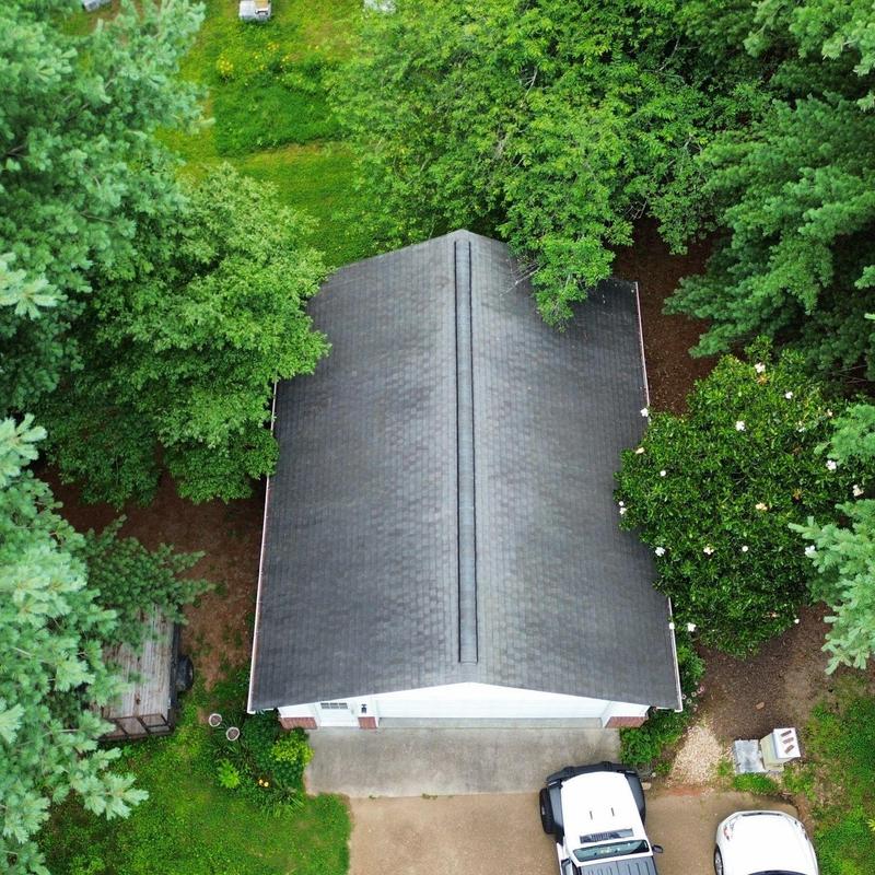 Roof shingles and ridge inspection surrounded by trees
