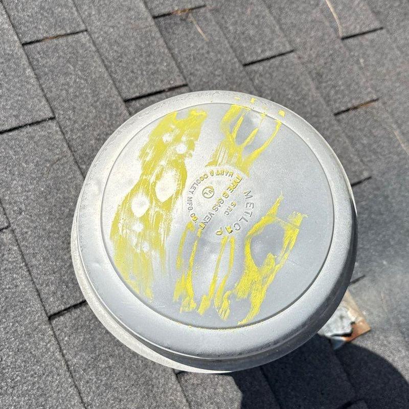 Metal vent cap on asphalt shingle roof with markings