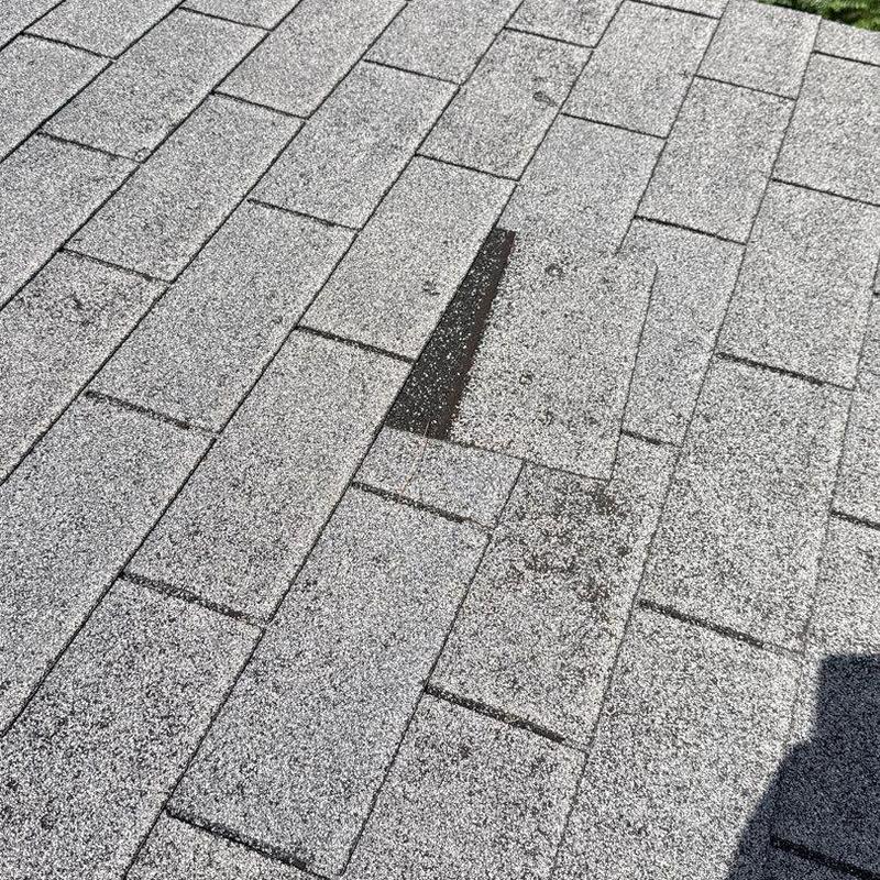 Asphalt shingle roof with damaged and missing shingles