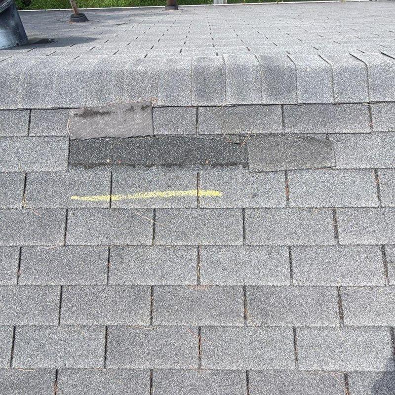 Asphalt shingle roof with wind and hail damage marks
