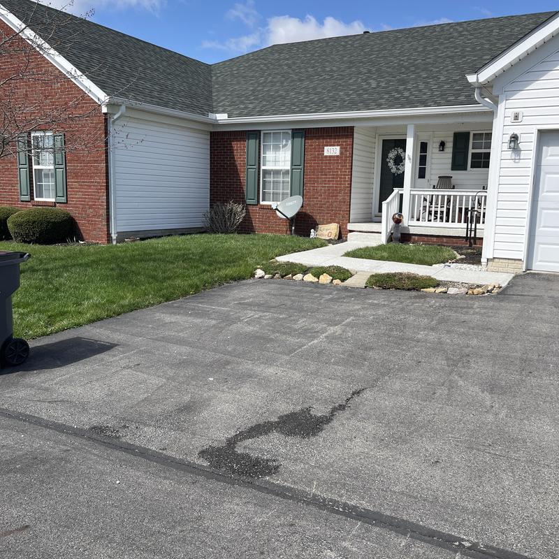Asphalt driveway with patch repair near home entrance Asphalt driveway with patch repair near home entrance