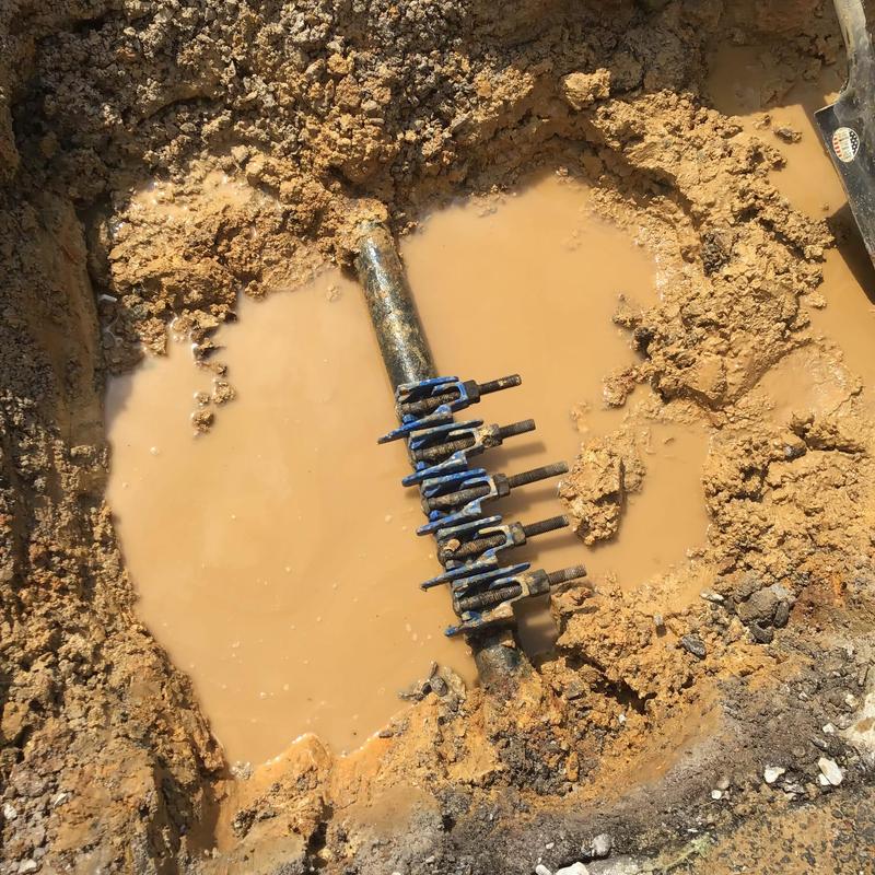 Water supply pipe with multiple valves in muddy trench