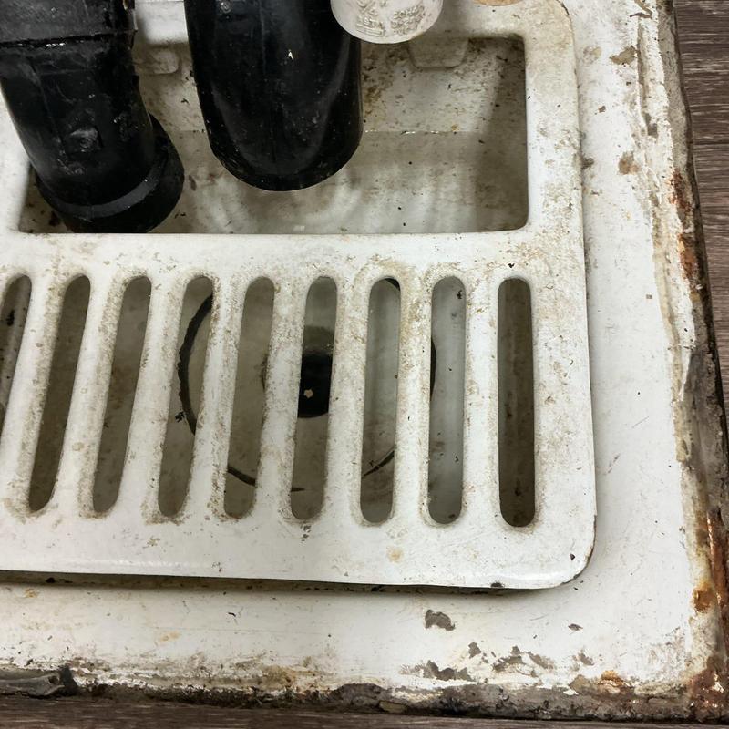 Grease trap with drain grate and black pipes Grease trap with drain grate and black pipes
