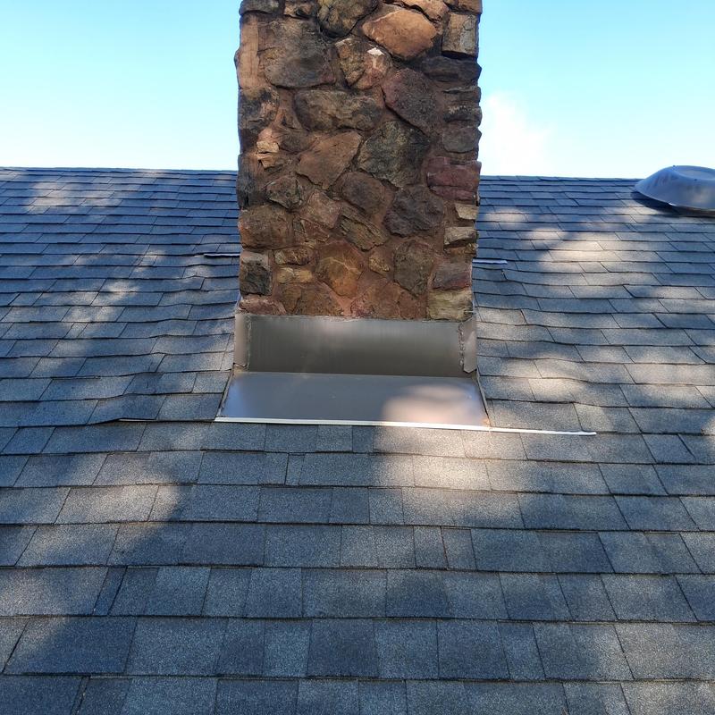 Chimney flashing with new roof shingles installation