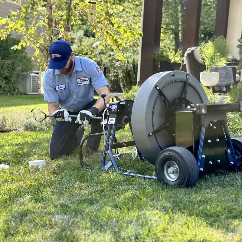 Drain cleaning machine with technician in yard