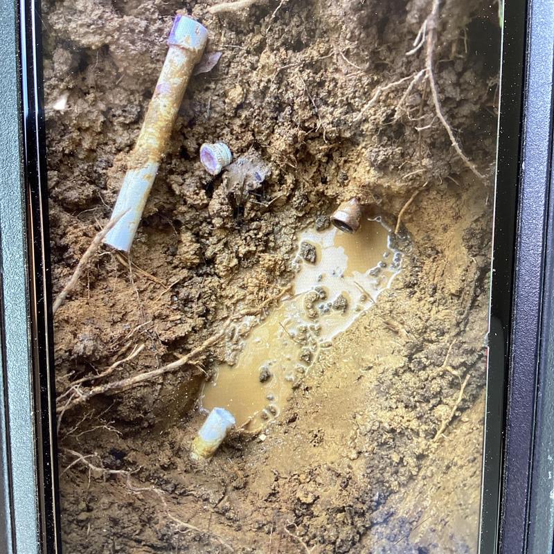 PVC water pipe leak with muddy water and broken pipe parts