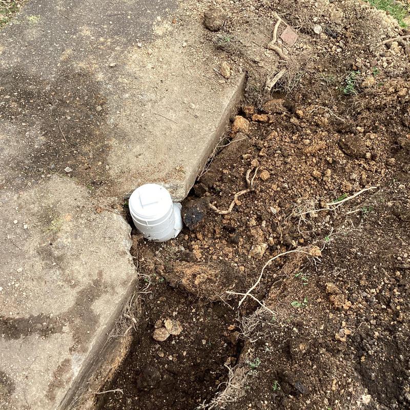 Sewer cleanout pipe exposed with dug-up soil