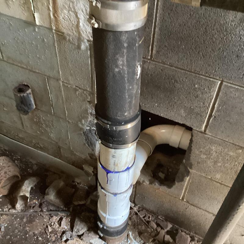 Service main line with PVC and cast iron pipes in wall opening