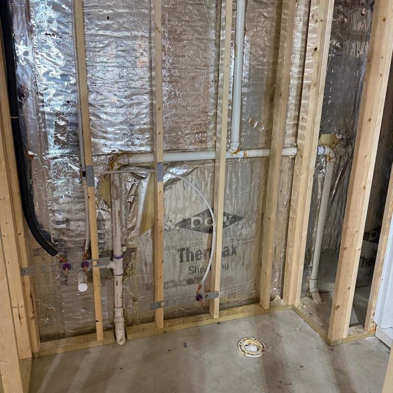 Basement plumbing rough-in with PVC pipes installed