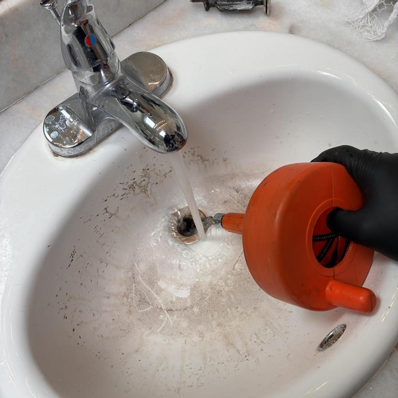 Basin sink drain clearing with manual plumbing auger