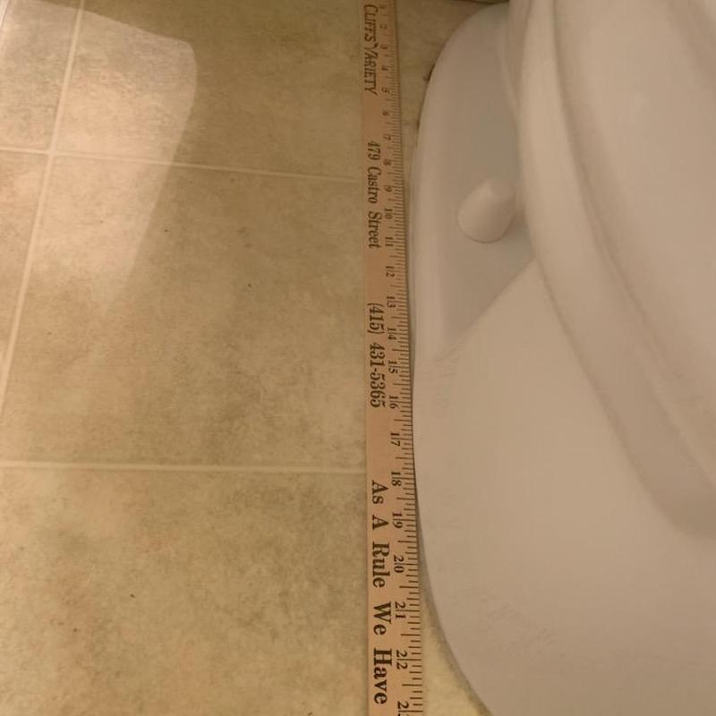 Toilet base with measuring ruler on tiled floor