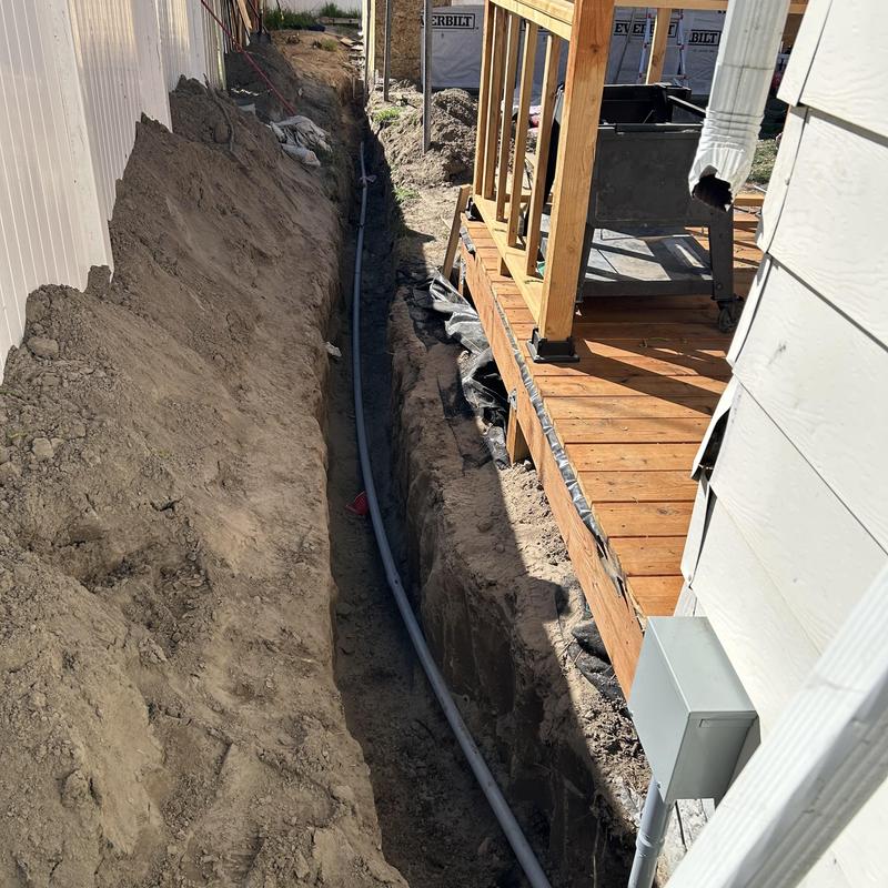 Underground PVC conduit trench beside wooden deck Underground PVC conduit trench beside wooden deck