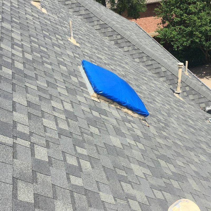 Skylight covered with blue tarp on slate roof Skylight covered with blue tarp on slate roof