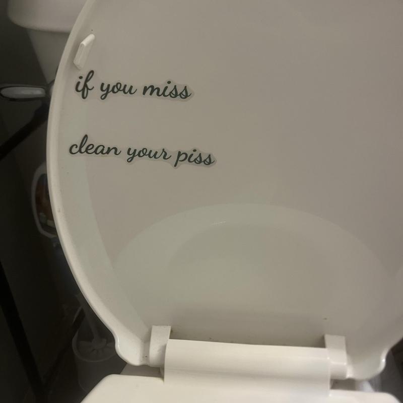Toilet seat with humorous cleaning reminder decal Toilet seat with humorous cleaning reminder decal