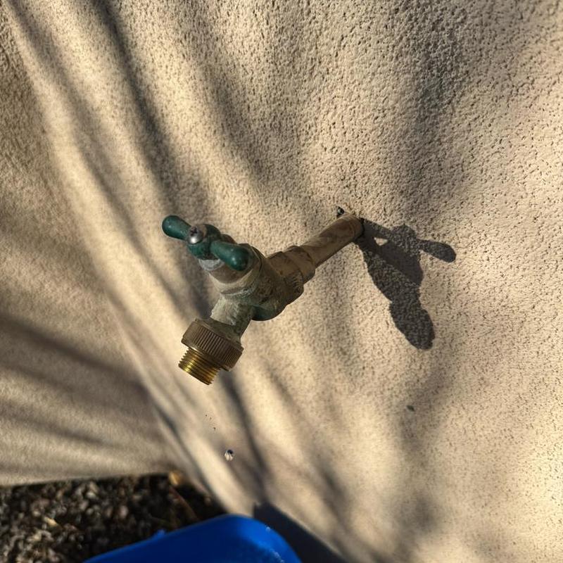 Hose bib dripping from outdoor faucet in stucco wall