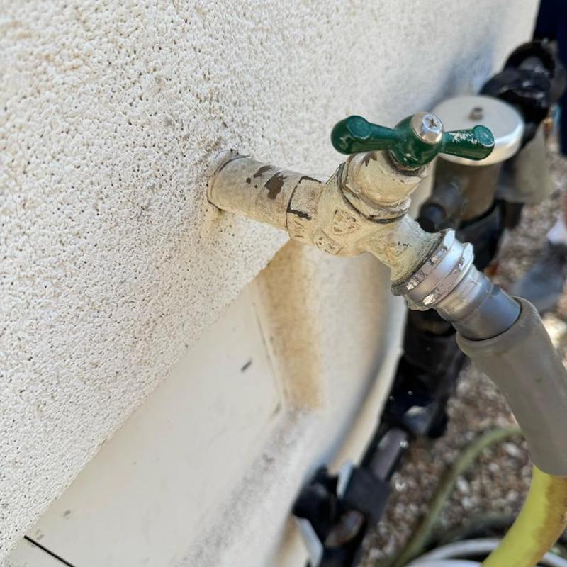 Sweat hose bib with attached garden hose outdoors