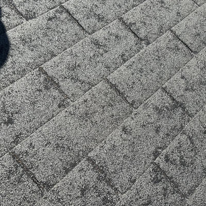 Asphalt roof shingles with hail damage close-up