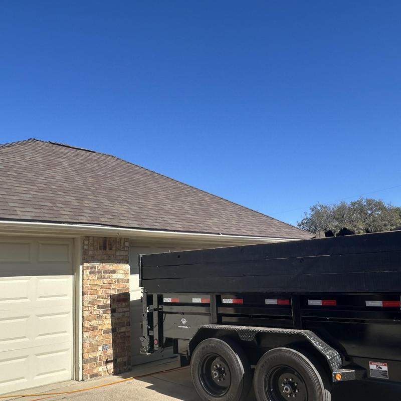 Architectural shingle roof with black trailer parked nearby
