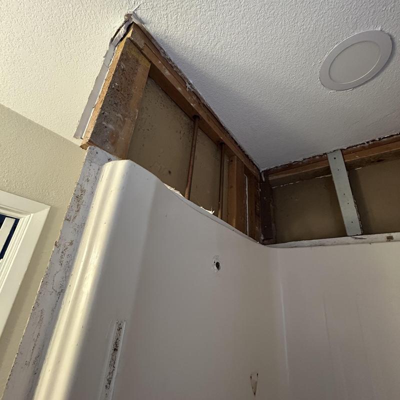 Sheetrock removed around shower corner for repair estimate