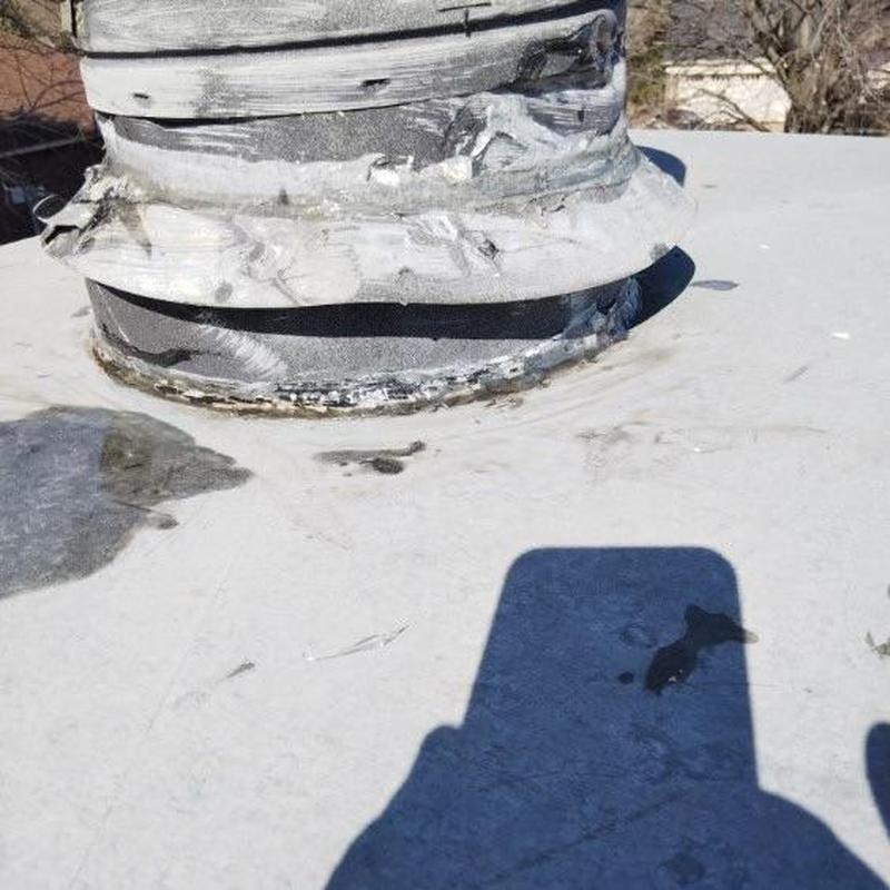 Aged chimney pipe flashing on flat roof
