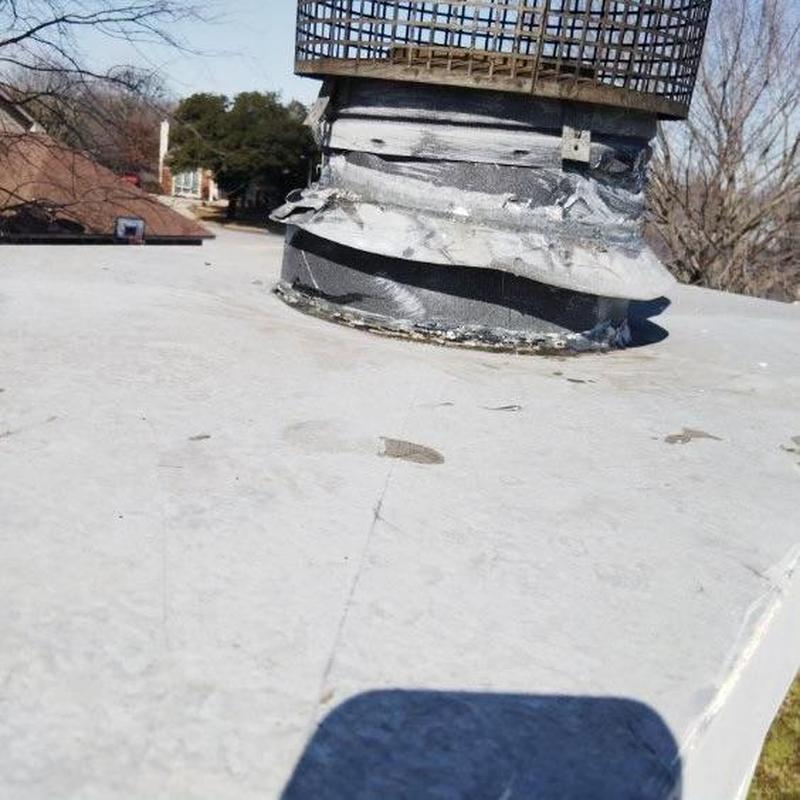 Aged chimney cap with damaged flashing on roof