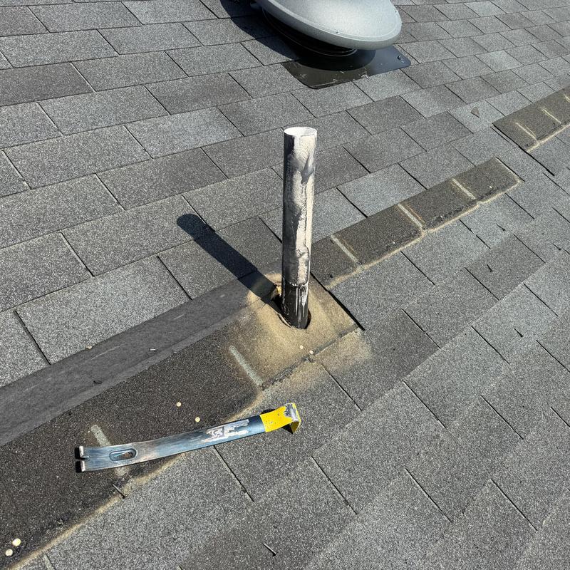 Roof pipe boot with damaged flashing on shingle roof