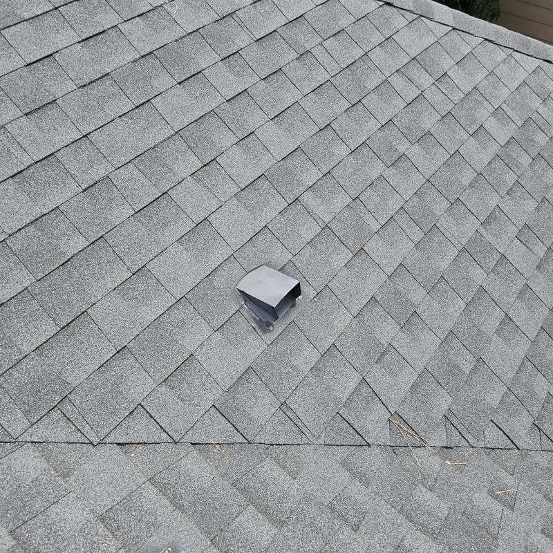Asphalt shingle roof with hail damage near vent pipe