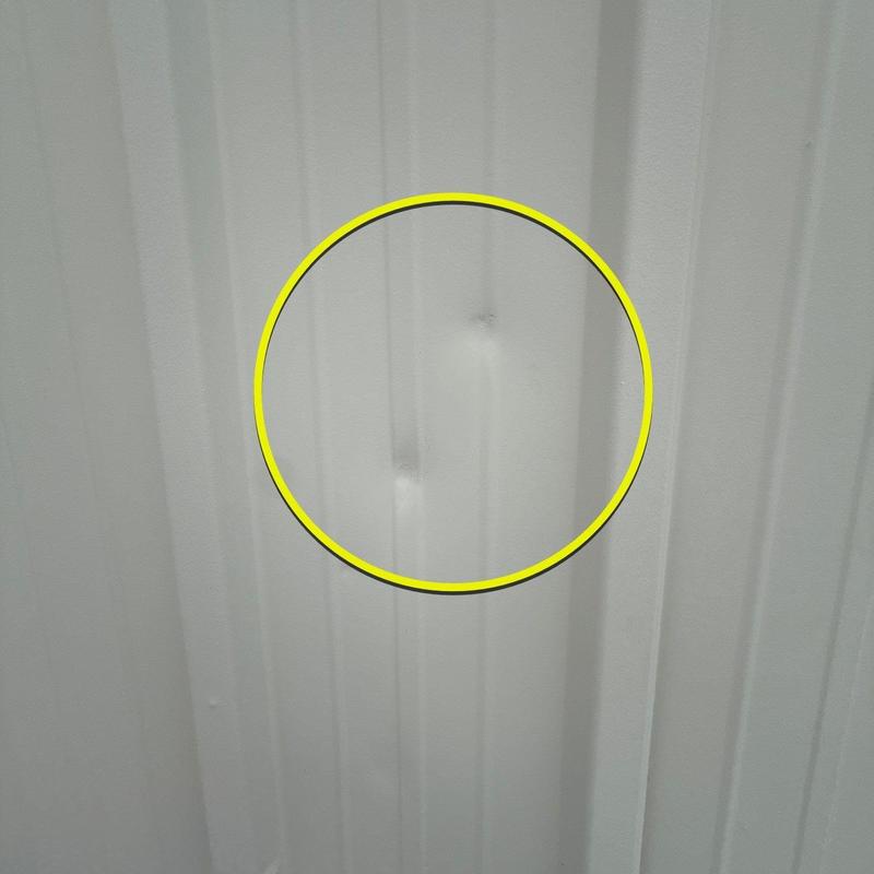 Metal roofing panel with hail damage dented area