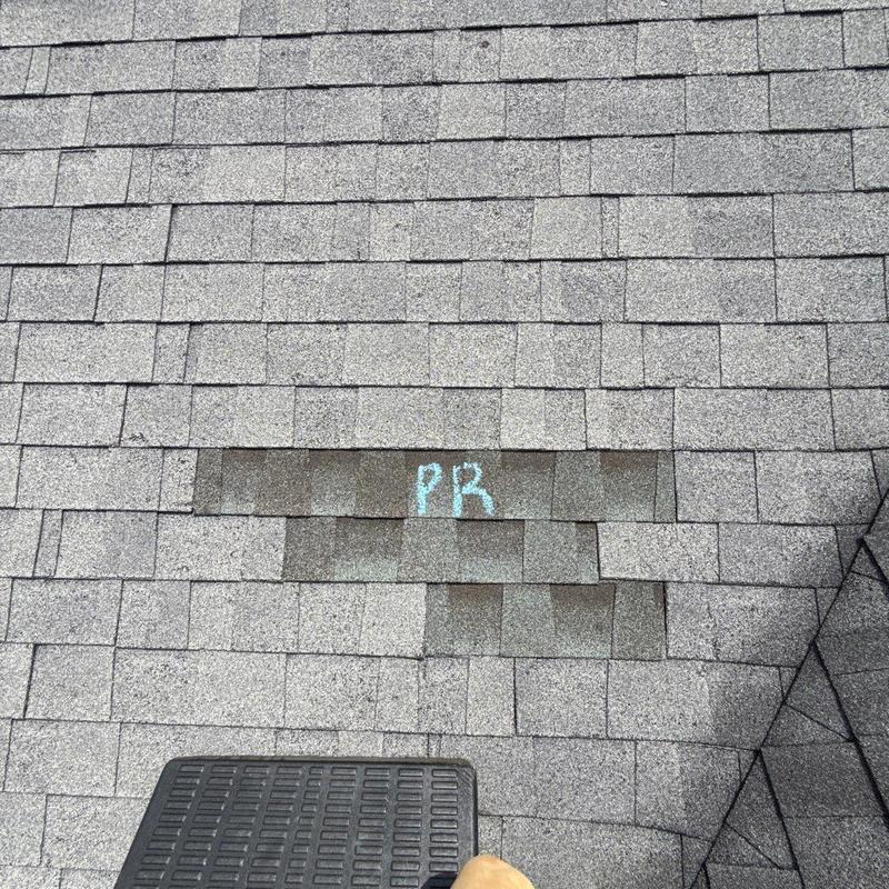 Roof shingles with marked hail damage and wear