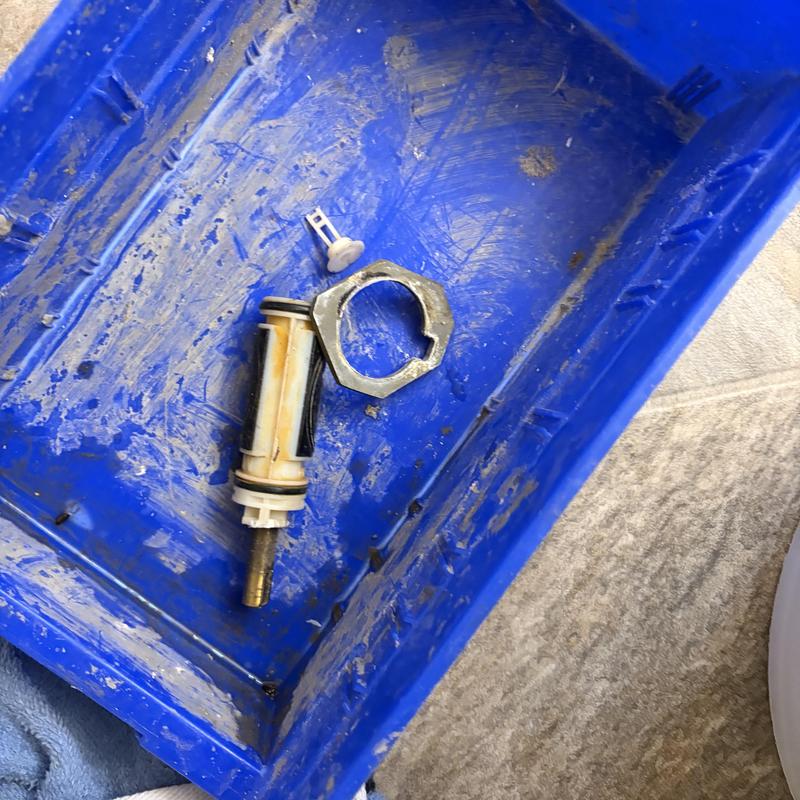 Shower cartridge and parts in blue container Shower cartridge and parts in blue container