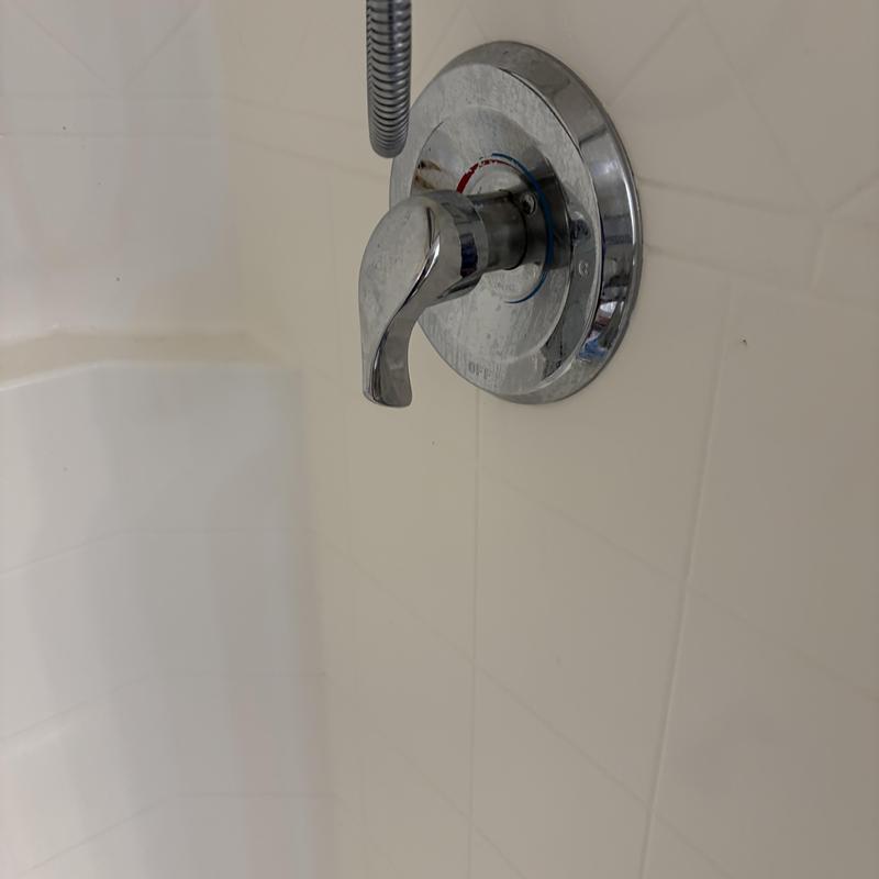 Shower valve handle and temperature dial on tiled wall Shower valve handle and temperature dial on tiled wall
