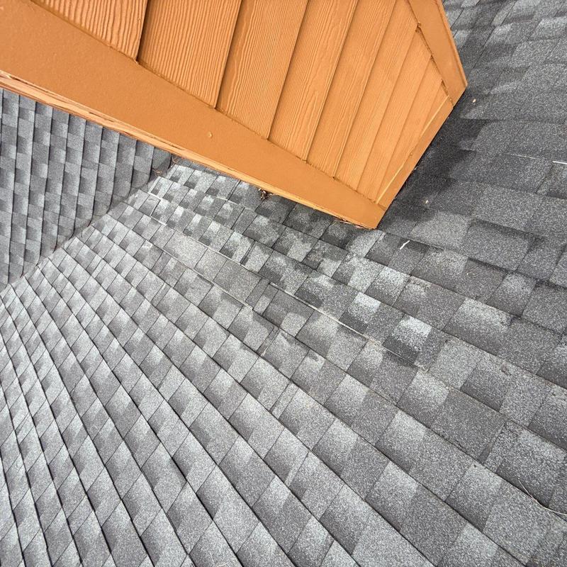 Asphalt shingle roof with early hail damage near dormer
