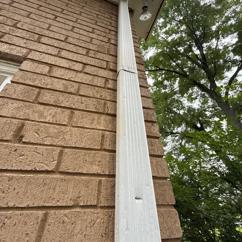 Downspout and brick wall exterior near eave light