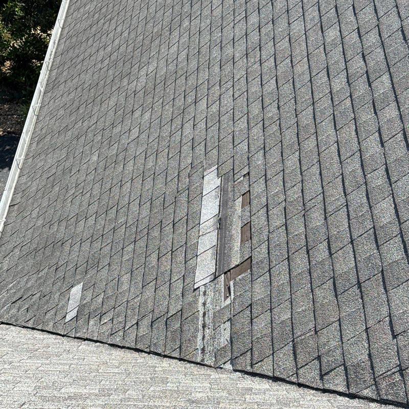 Asphalt shingles with hail and age damage on roof