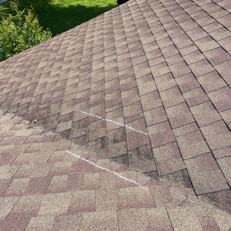 Roof shingles with hail damage marked for repair