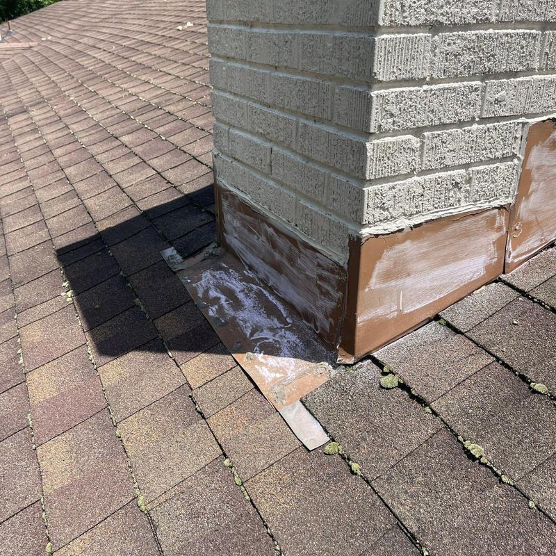Roof flashing around brick chimney with sealant application