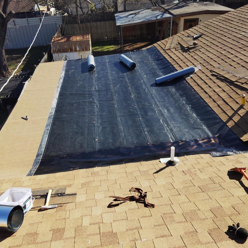 Flat roof black membrane installation in progress