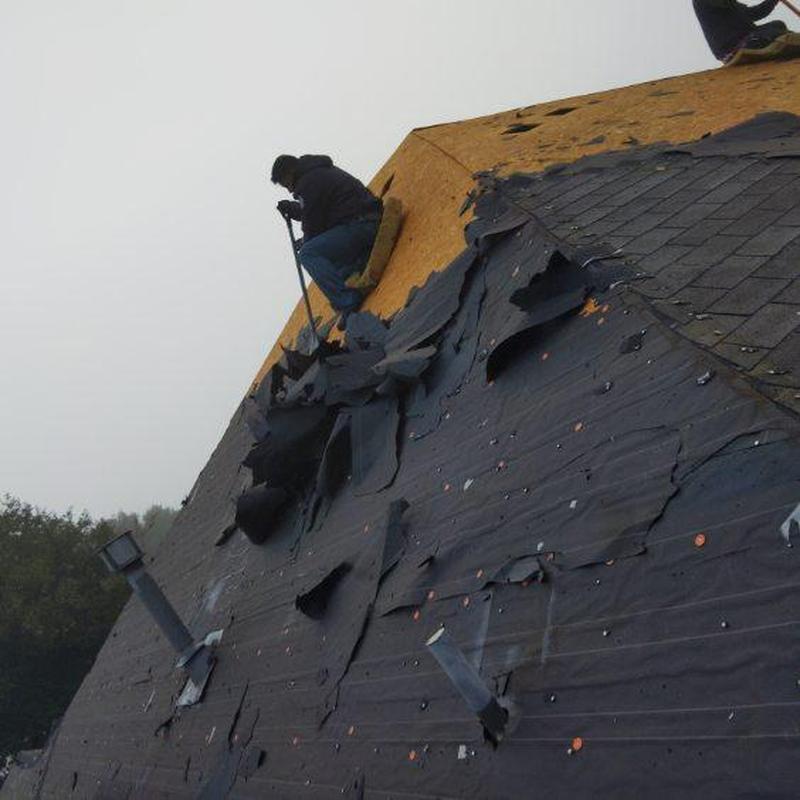 Roof decking exposed with removed shingles and felt paper
