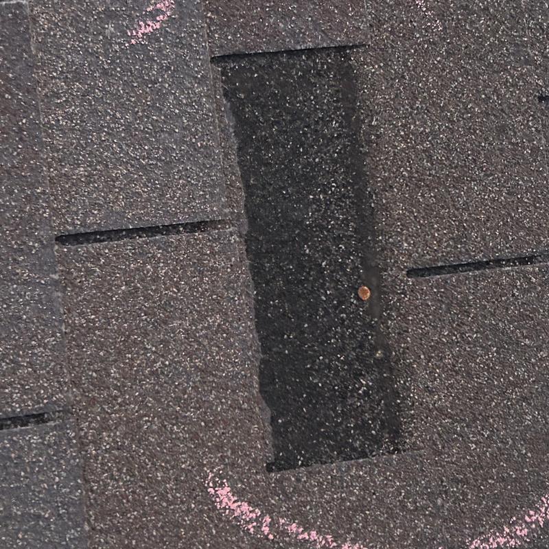 Asphalt roof shingles with exposed nail and chalk markings