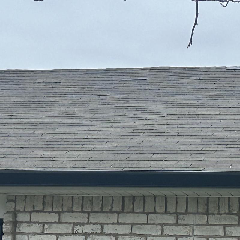 Asphalt shingle roof with visible damage and wear
