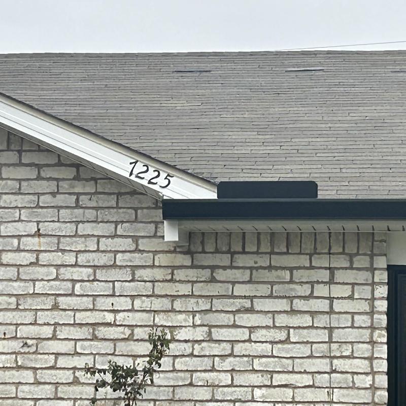 Asphalt roof shingles with minor wear near gutter edge
