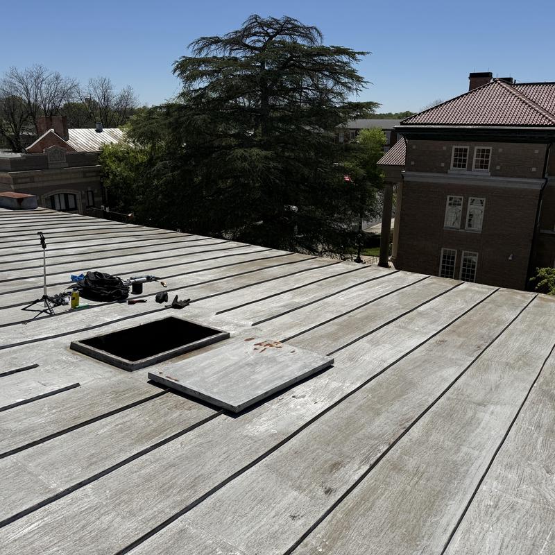 Standing seam metal roof with open hatch and tools