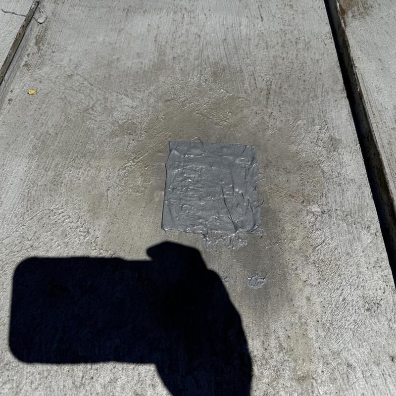 Concrete driveway patch with fresh sealant application