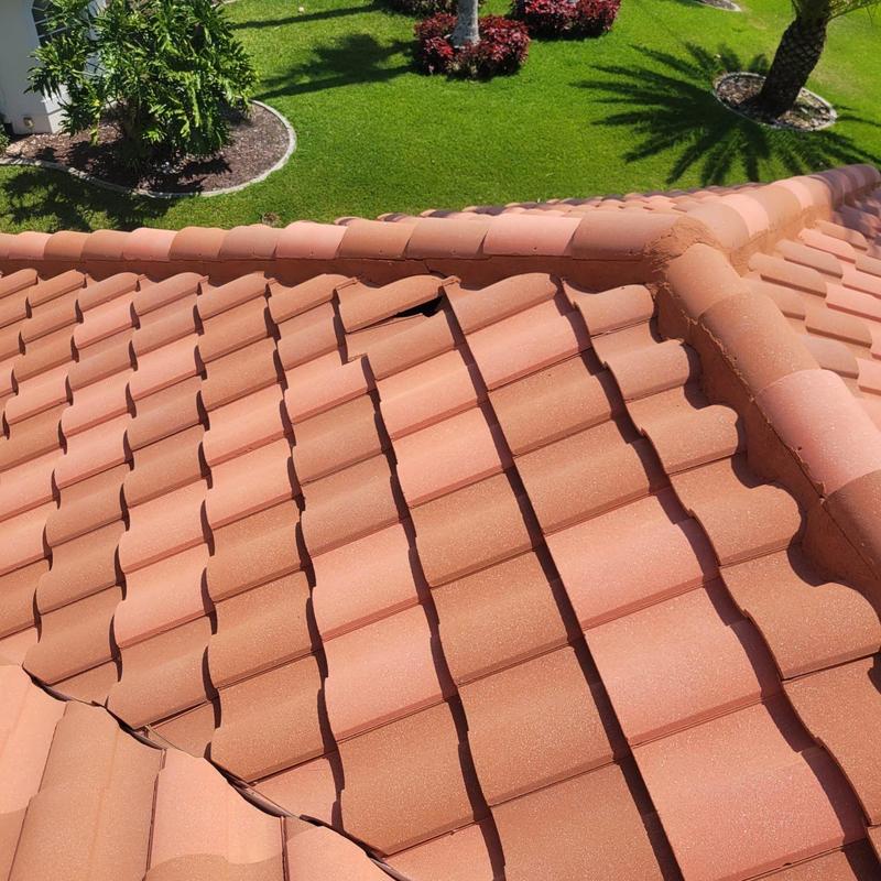 Tile roof with secured displaced tiles and underlayment