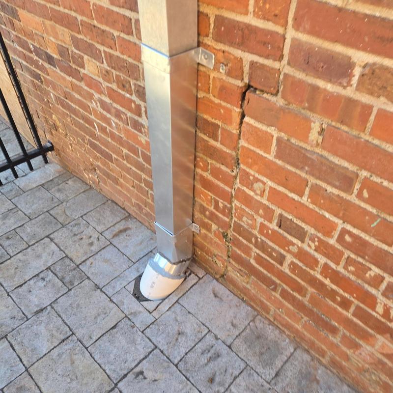 Commercial downspout and drain system on brick wall Commercial downspout and drain system on brick wall