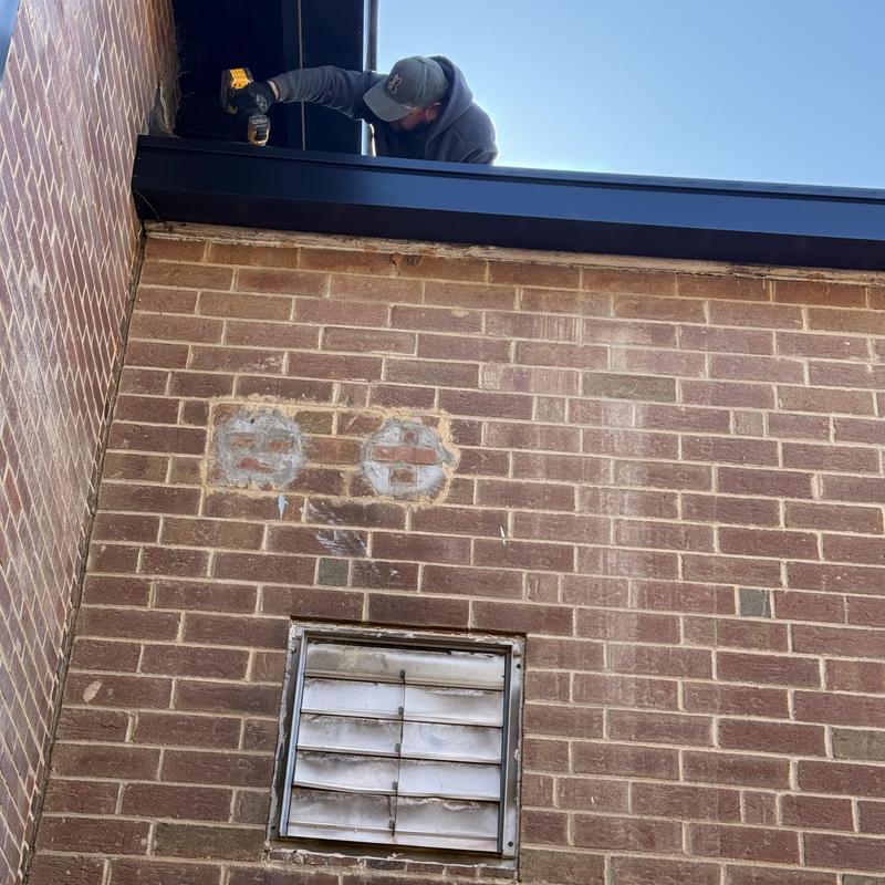 Commercial gutter and downspout installation on brick wall Commercial gutter and downspout installation on brick wall