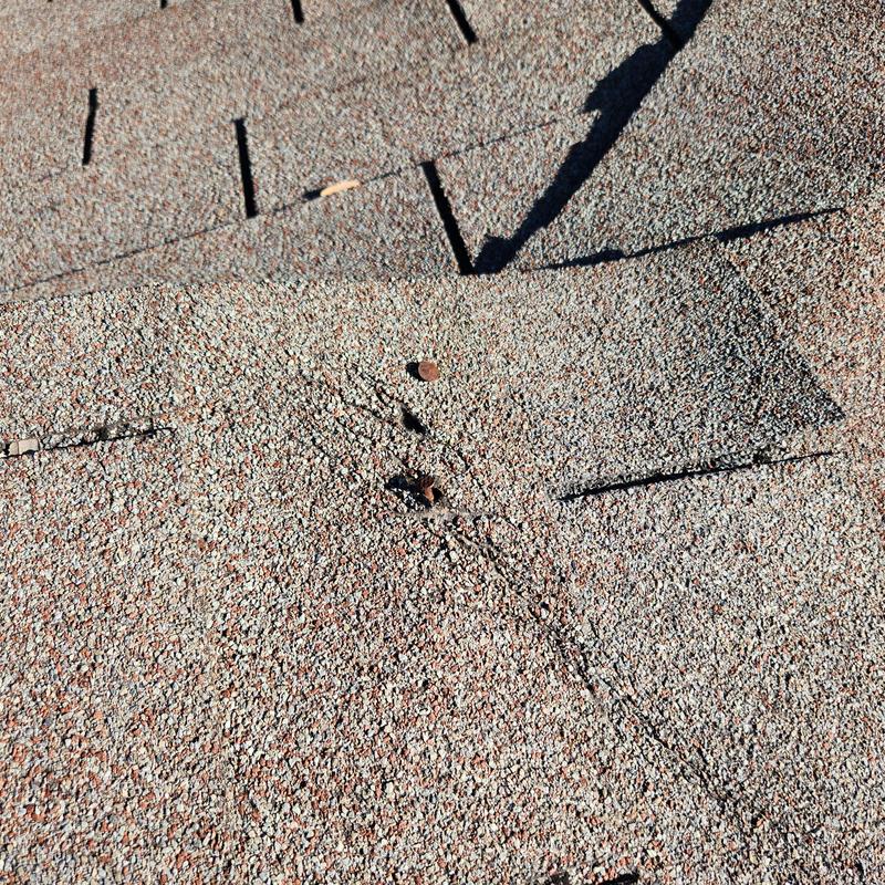 Asphalt shingles with protruding staples and damage Asphalt shingles with protruding staples and damage