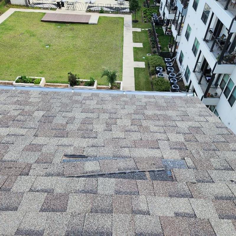 Asphalt roof shingles with damaged and missing areas