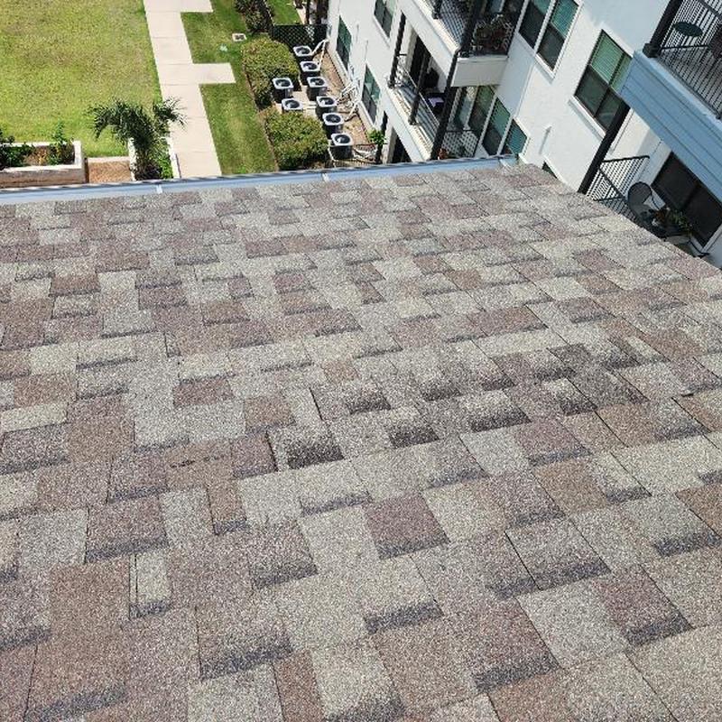 Apartment building shingle roof with new replacement shingles